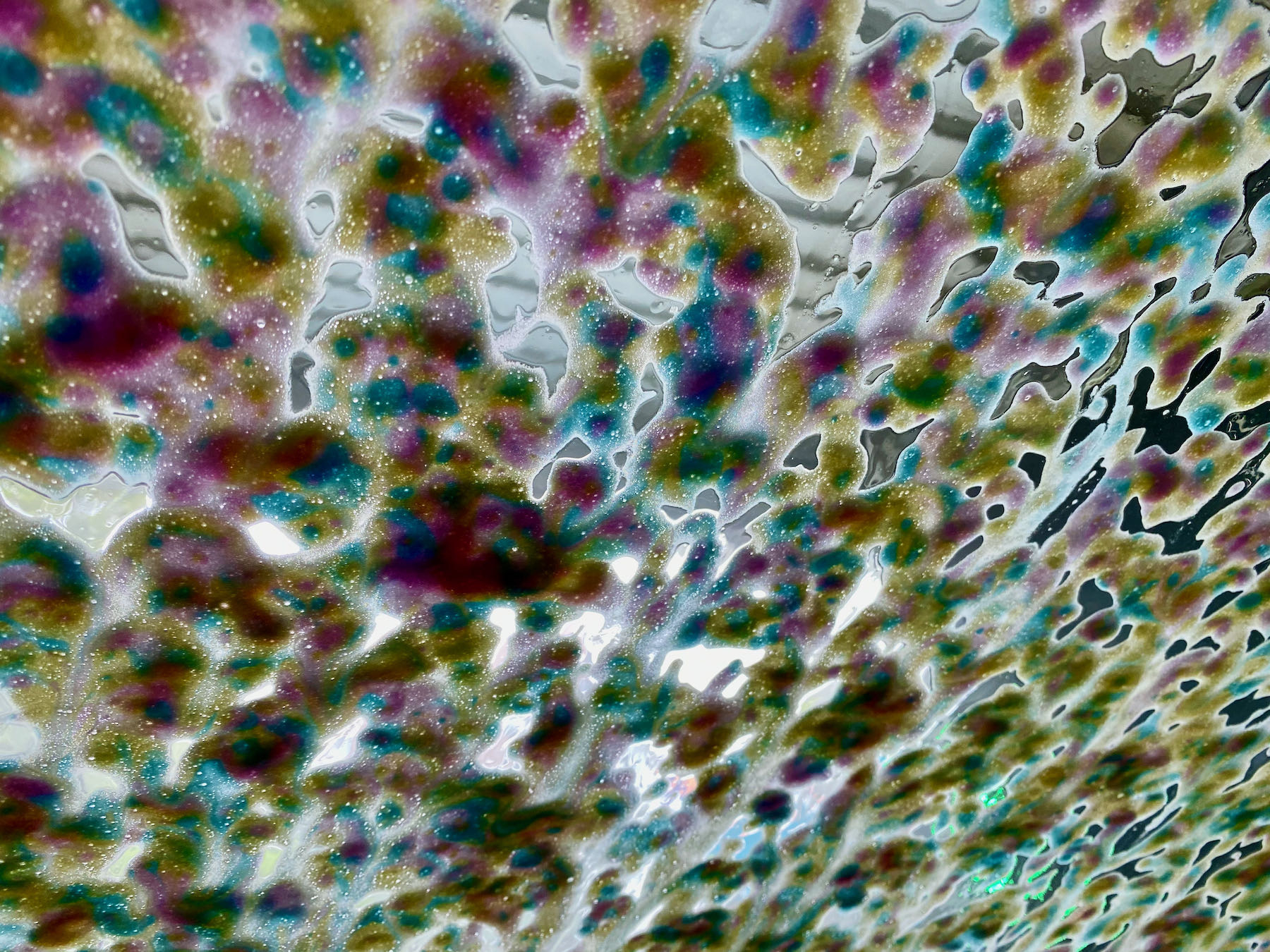 Multicoloured foam on the windcsreen, seen from inside the car.