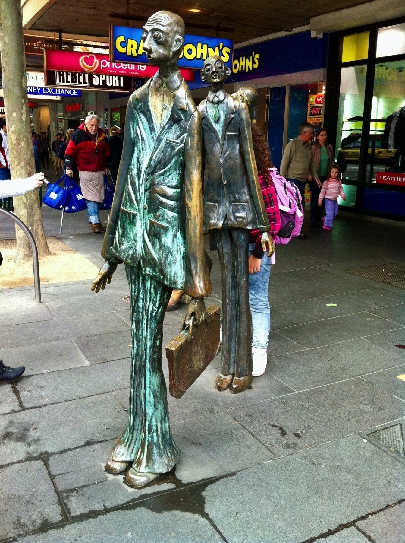 Life size statues of 3 skinny men. Another angle. 