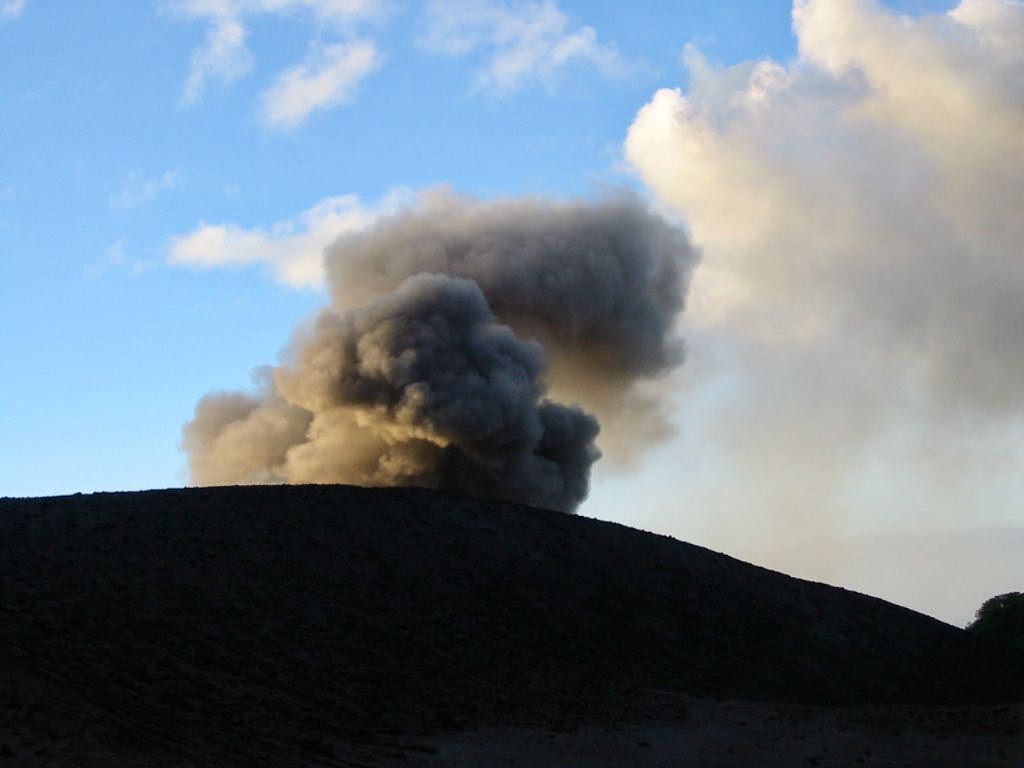 Dark smoke above the rime of the volcano. 