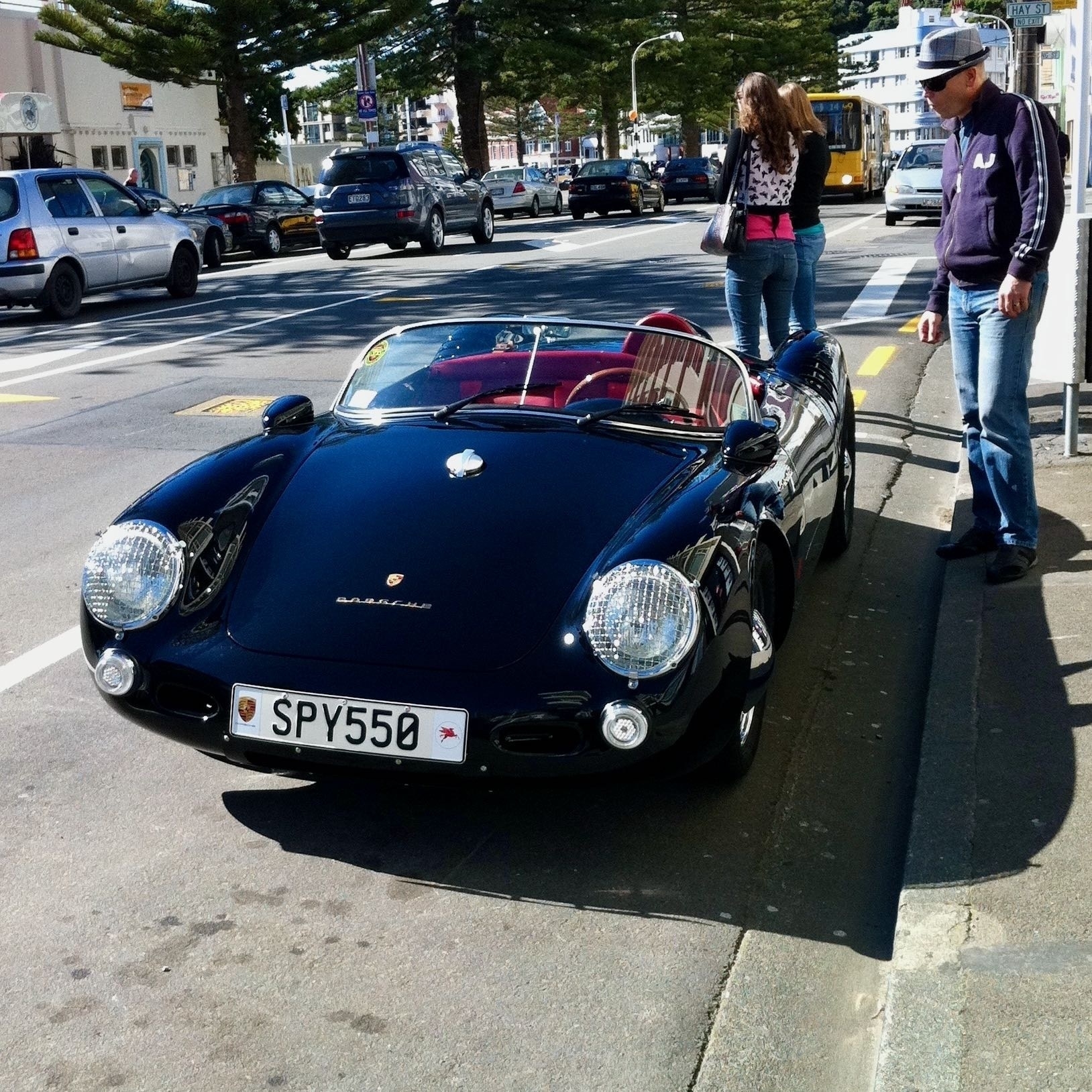 Porsche Spyder sports car front view, with a hipster admiring it. 