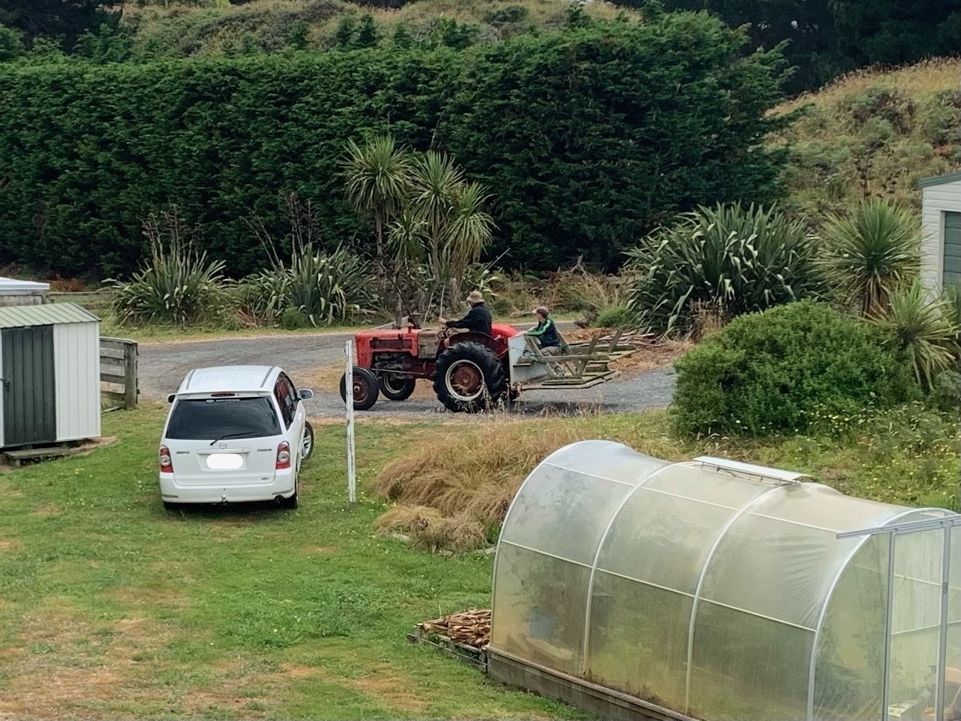 Tractor going out the gate with table and me on the rear platform. 