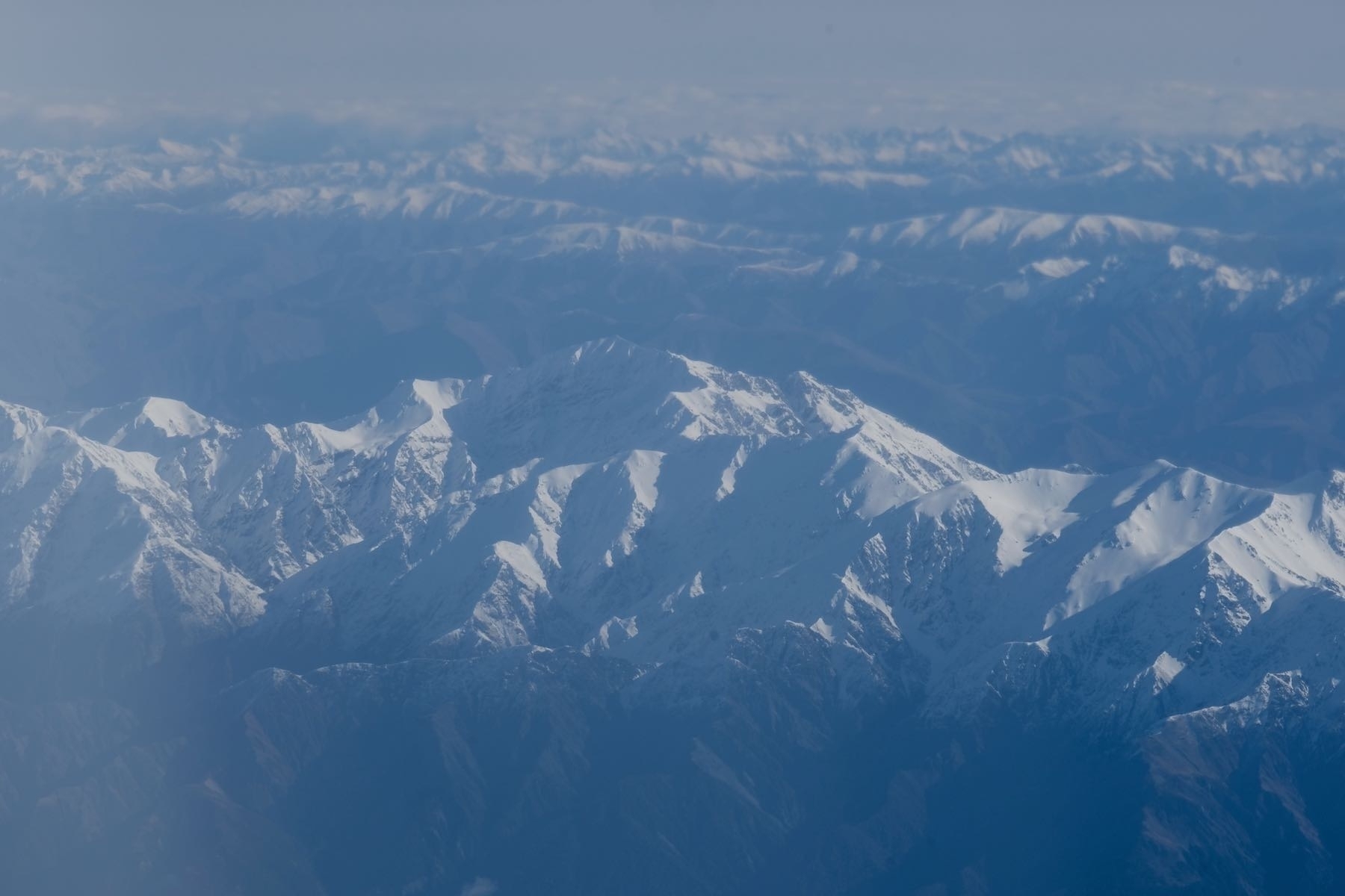 Snow topped mountains from a plane window. 