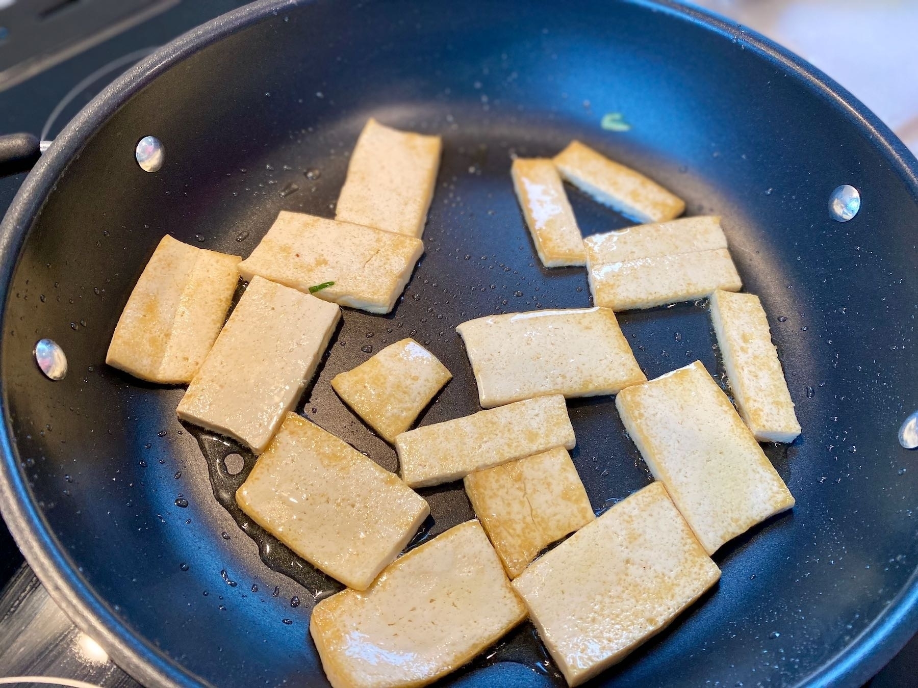 Tofu coooking in a pan. 