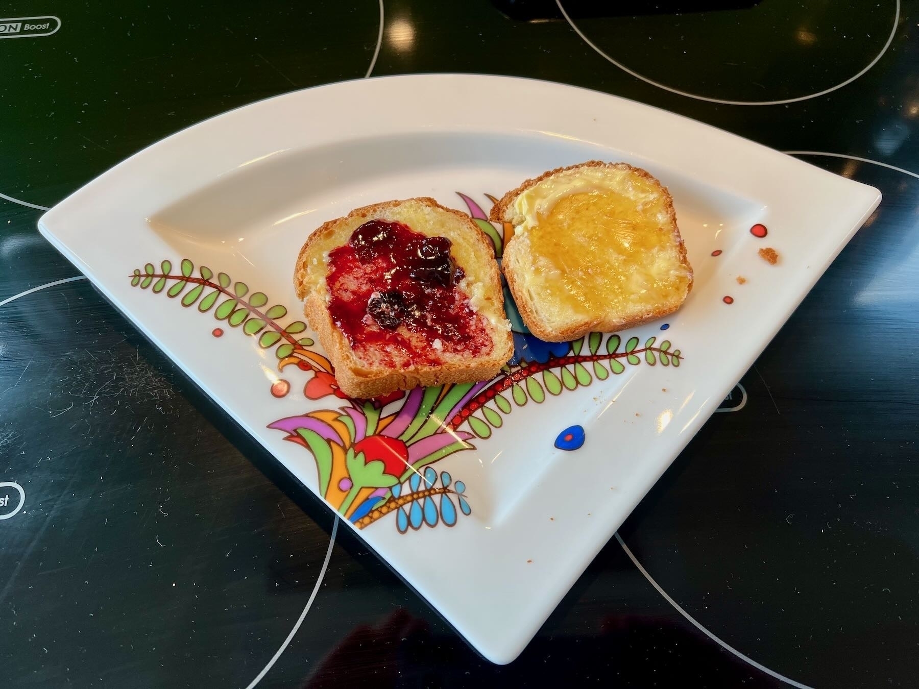 Two mini loaf slices on a plate, with butter and jam or honey. 