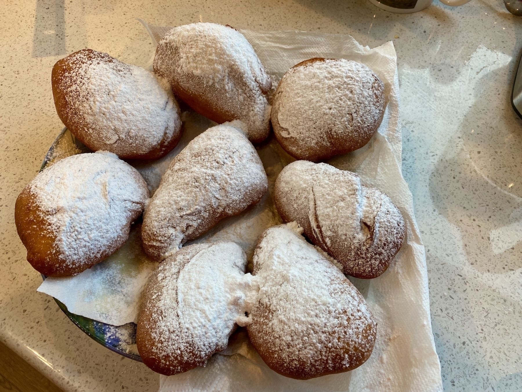 The finished donuts, sprinkled with icing sugar. 