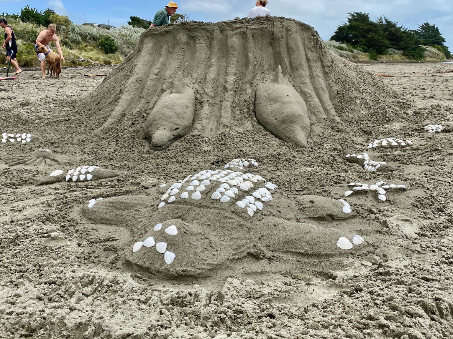 Sand sculpture of surfing dolphins, a turtle and more. 