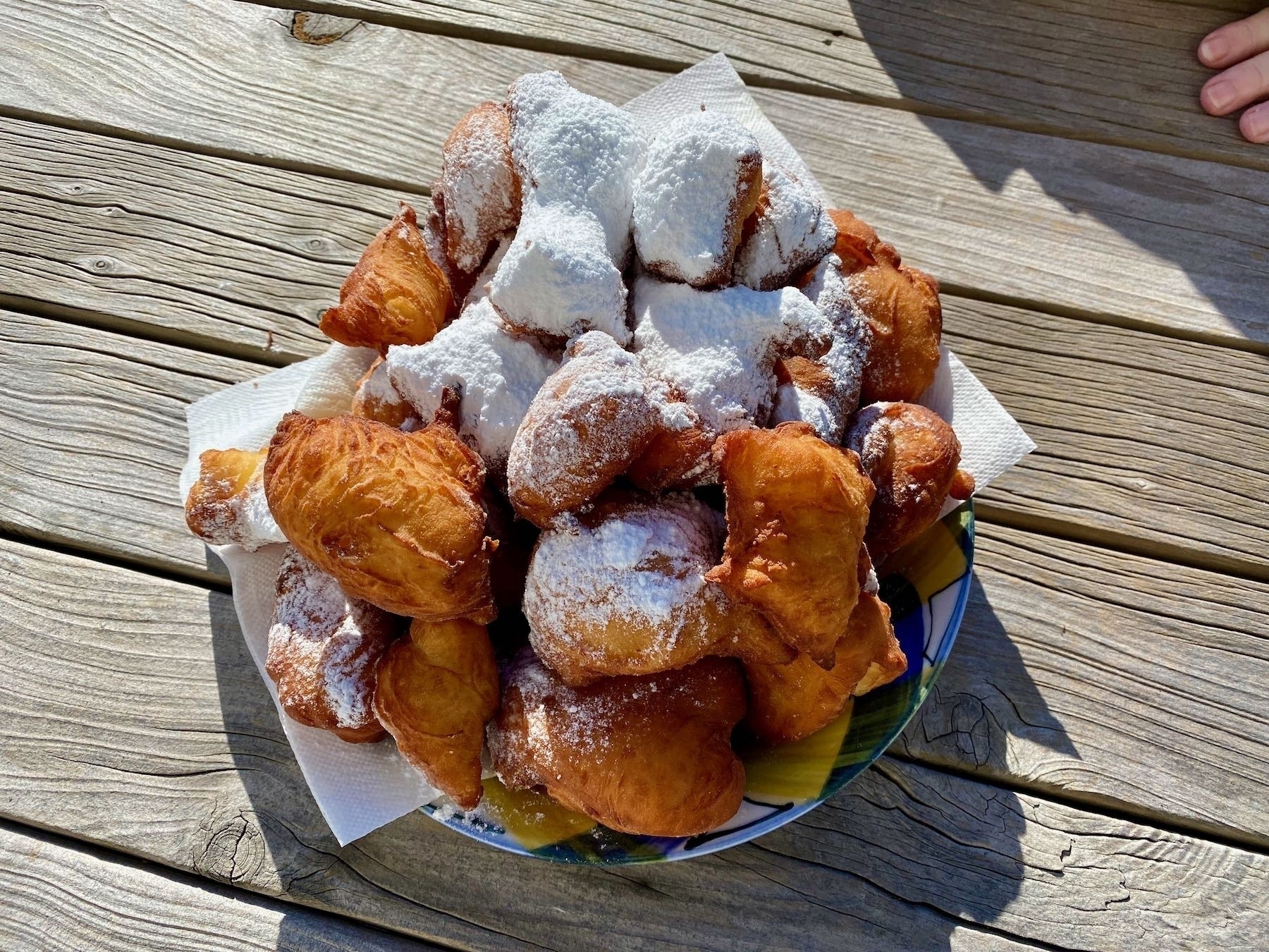 A plate of beignets sprinkled with icing sugar. 