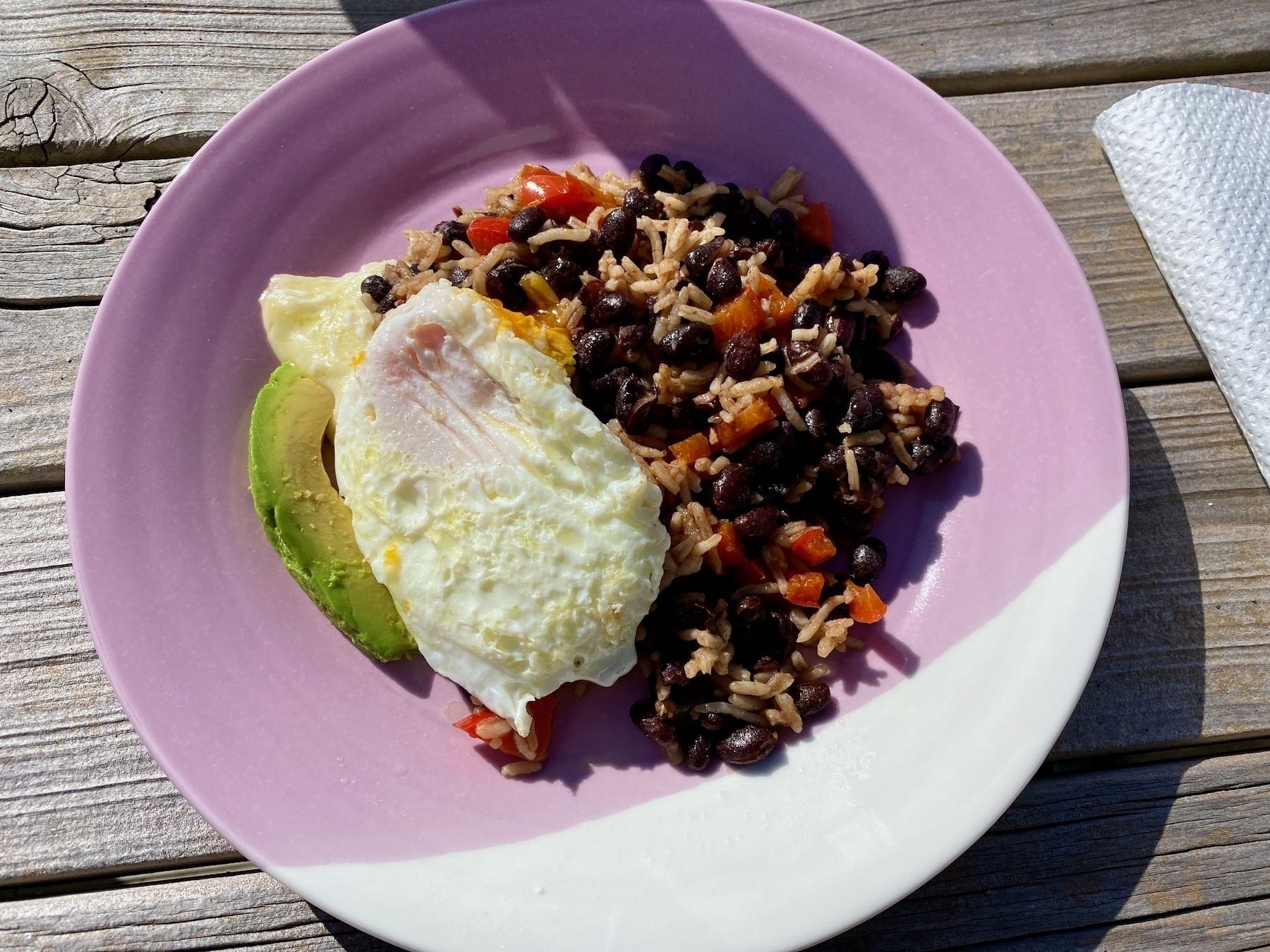 Gallo Pinto served on a plate with cooked cheese, avocado, fried egg. 