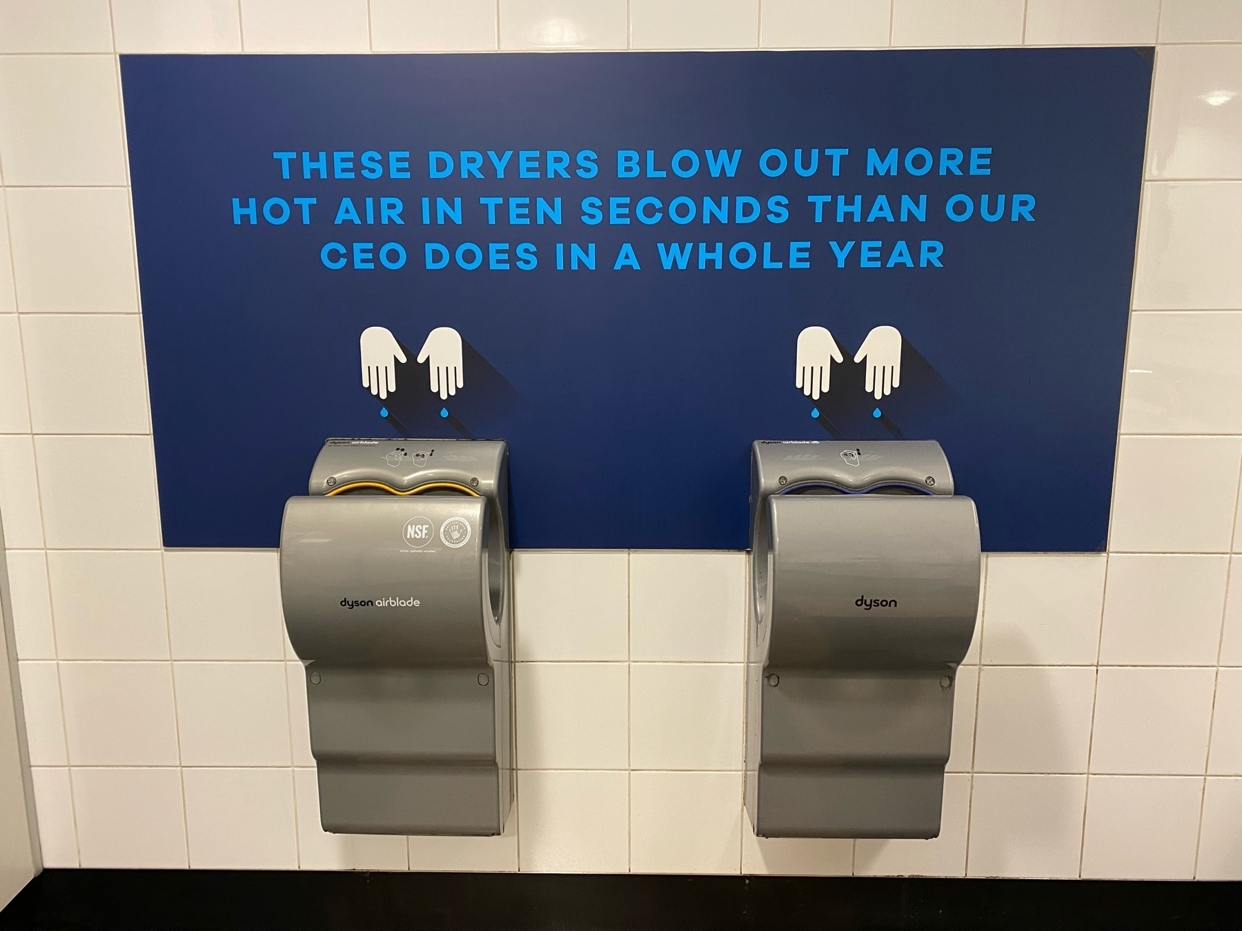 Hot air hand dryers with sign that says These dryers blow out more hot air in 10 seconds than our CEO does in a year. 