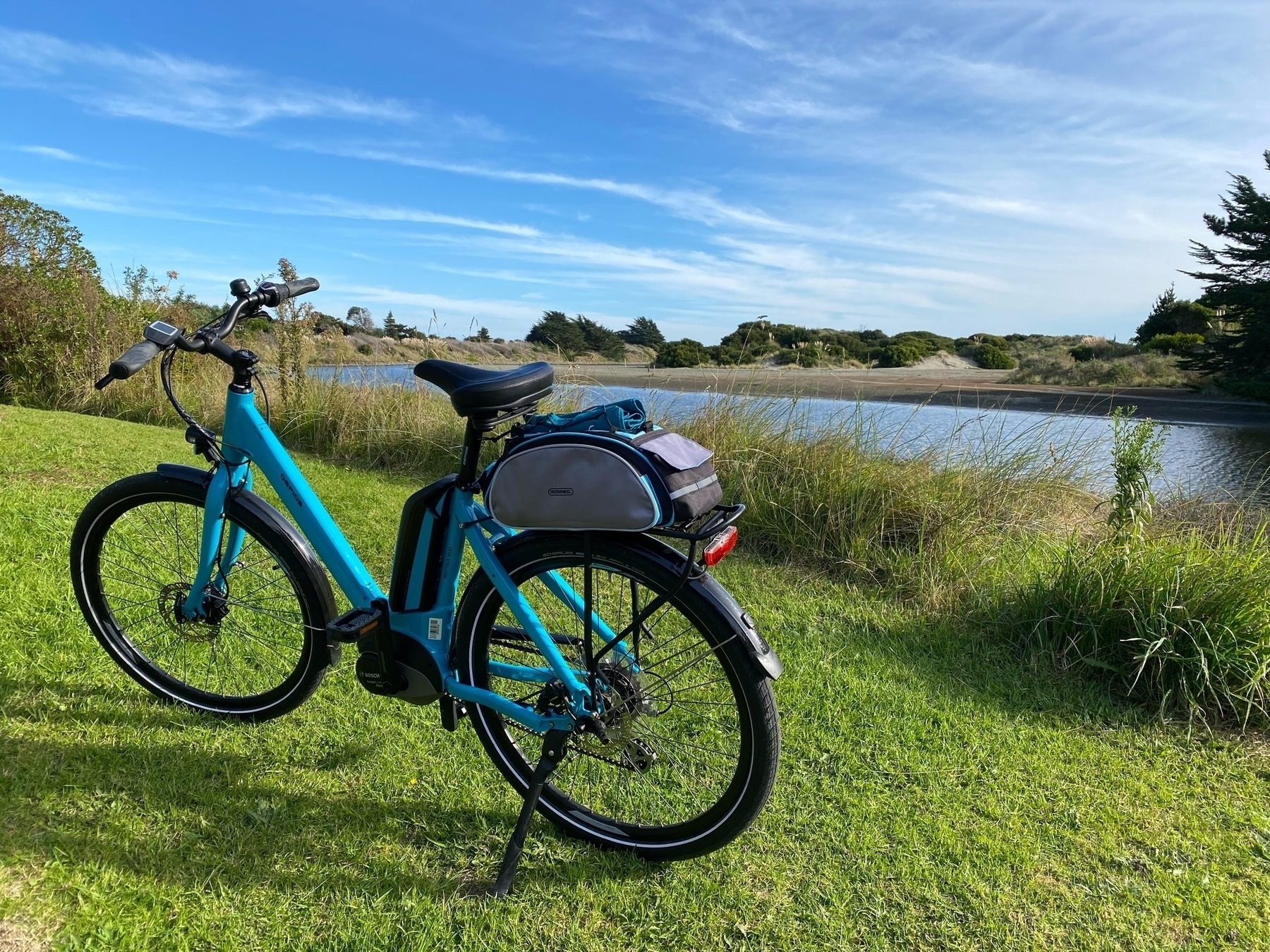 Blue bicycle beside river. 