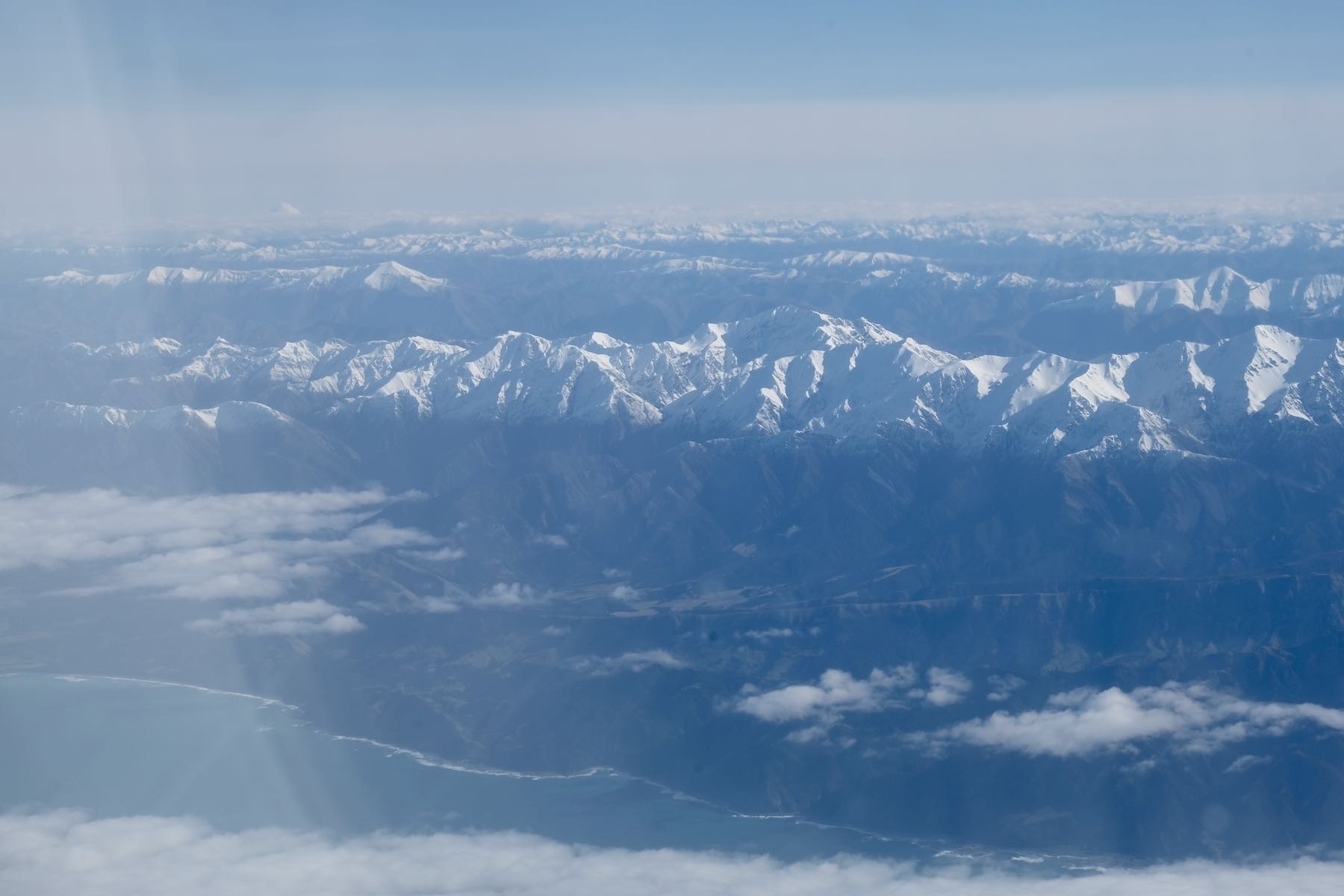Snow topped mountains from a plane window. 