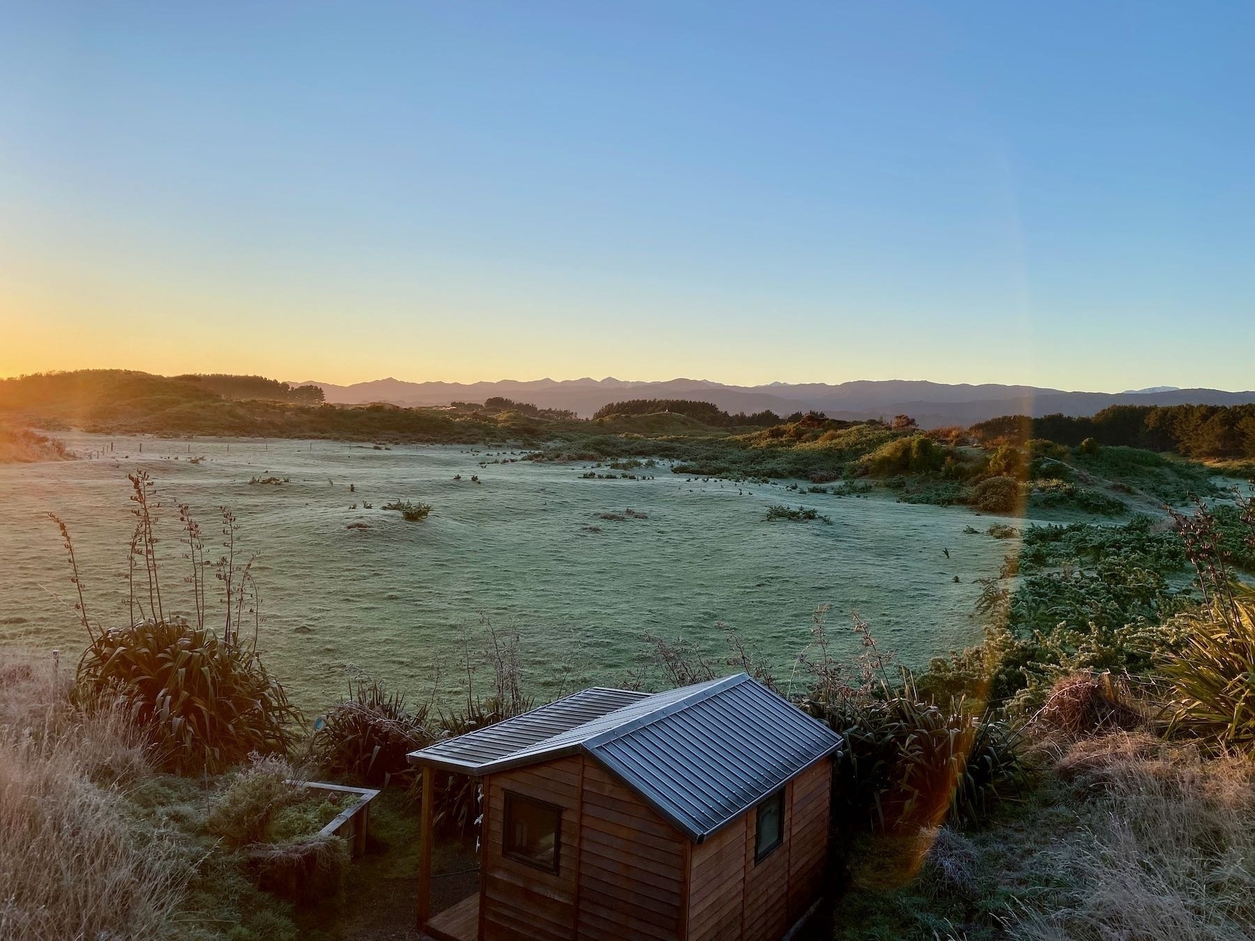 Frosty paddocks with sun just at the left edge. 