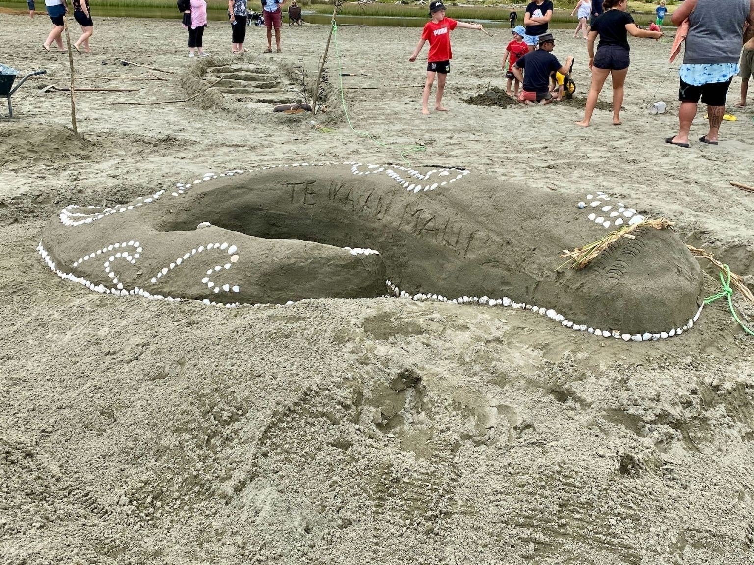 A sand sculpture of a fish. 