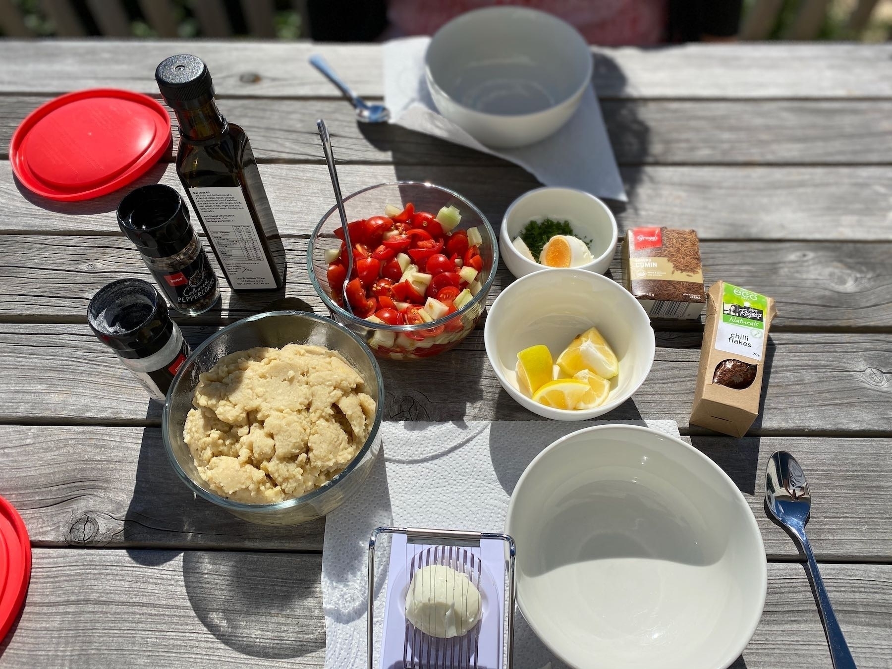 Breakfast ingredients spread on a picnic table. 