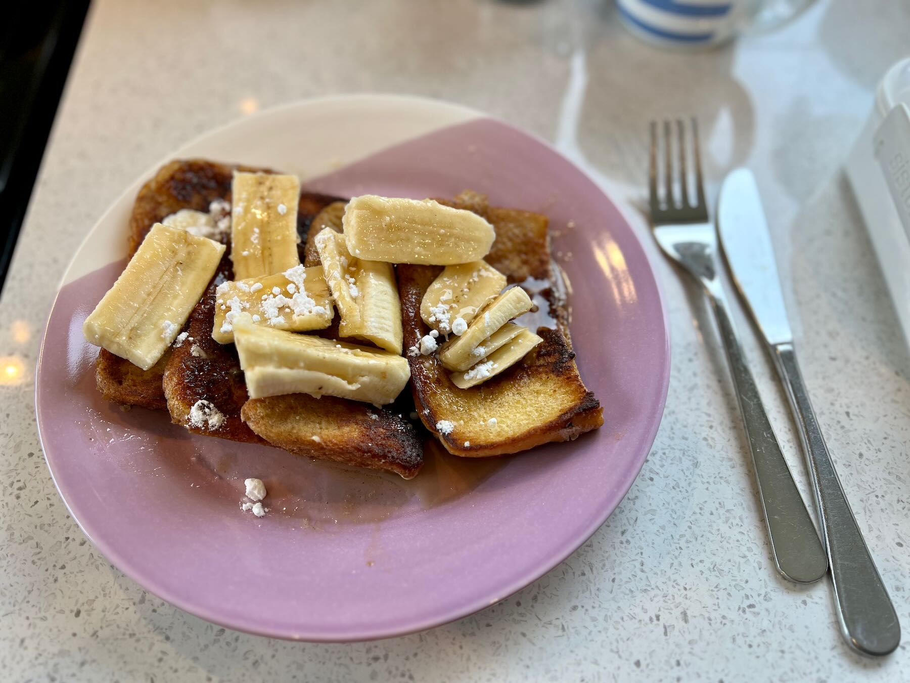 French Toast with Banana and Maple Syrup on a plate. 