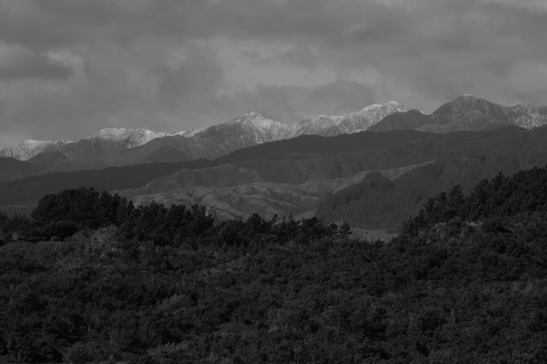 Snowy mountains and landscape in shades of grey. 