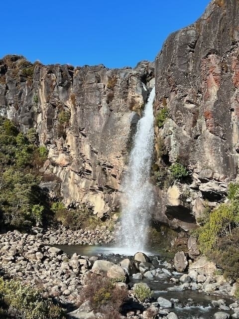 Taranaki Falls gush with force from between sheer rock cliffs. 