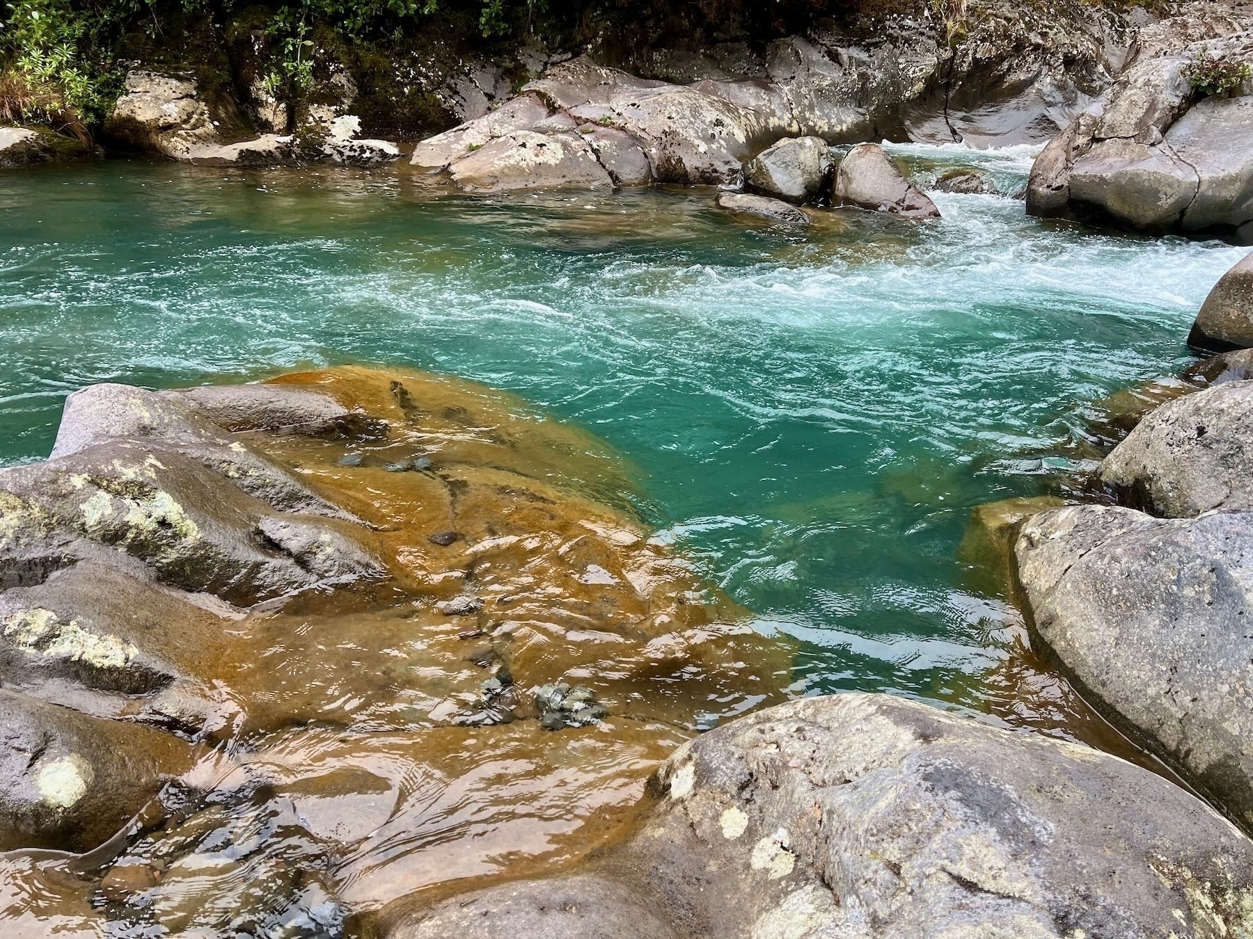 Tawhai Falls blue water and rocks in the river. 