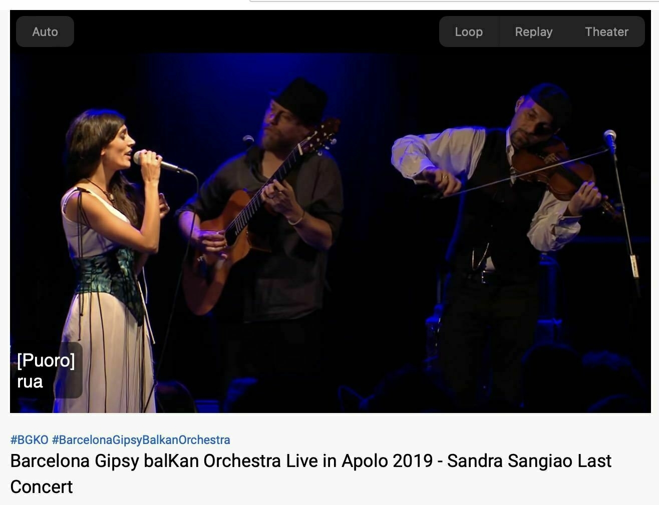 Screenshot showing Sandra Sangiao on stage singing with musicians playing. 