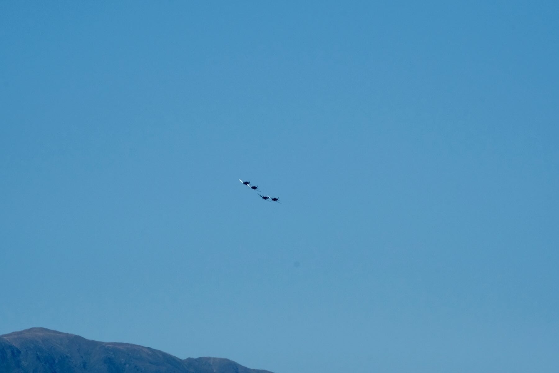 The 4 planes catch glints of light as they turn. 