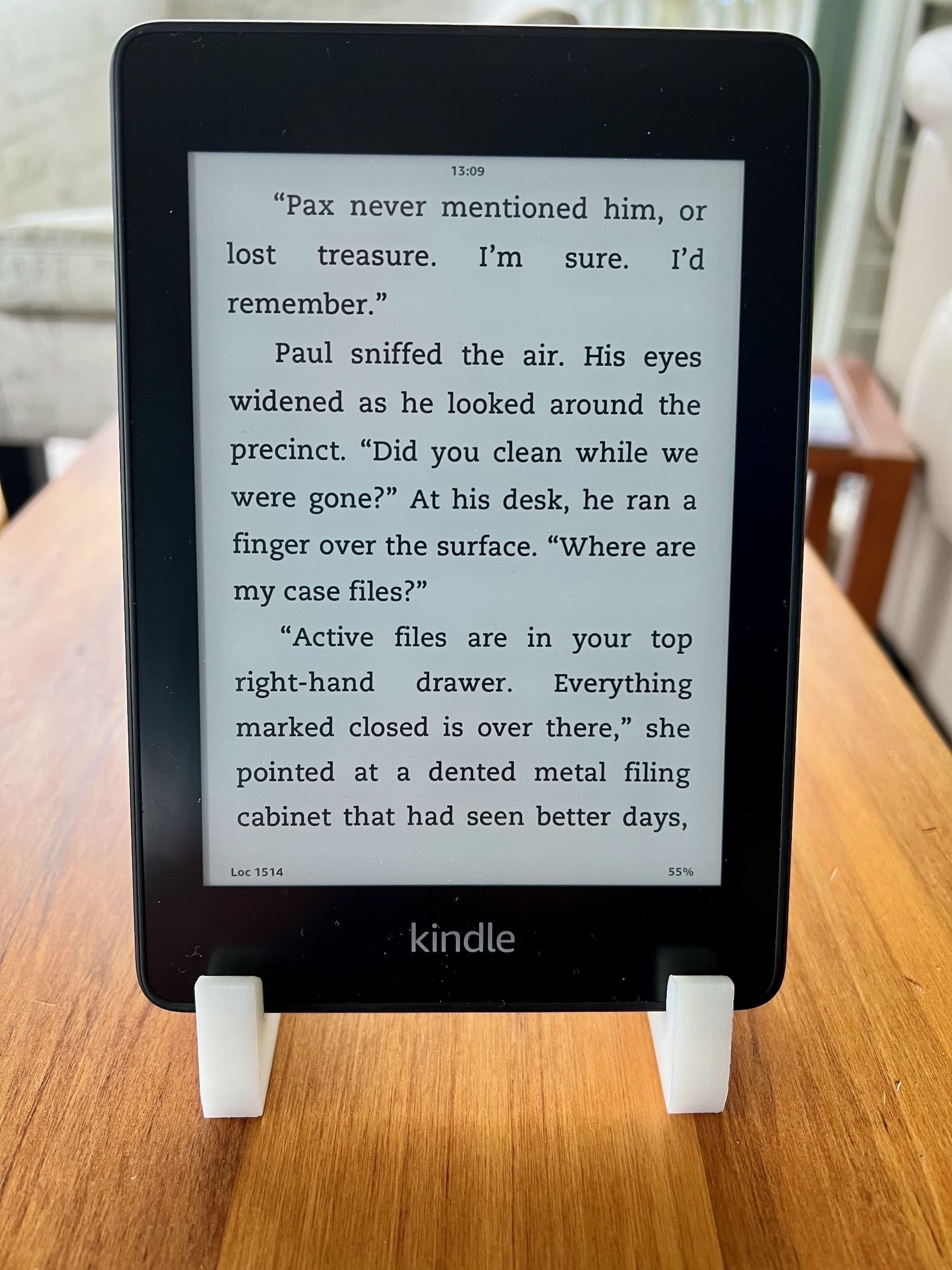 3D printed Kindle stand with Kindle, screen shows a page from @Cheri new book.   