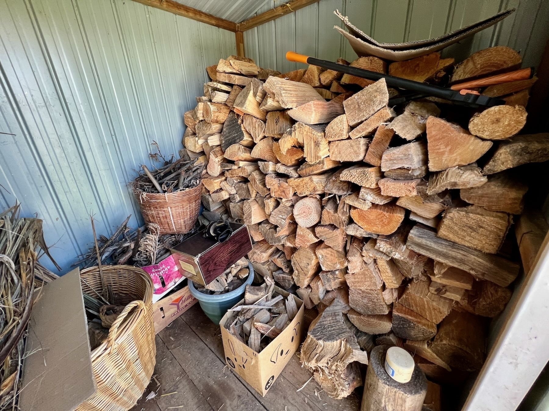 Stacked firewood on right side of the shed. 