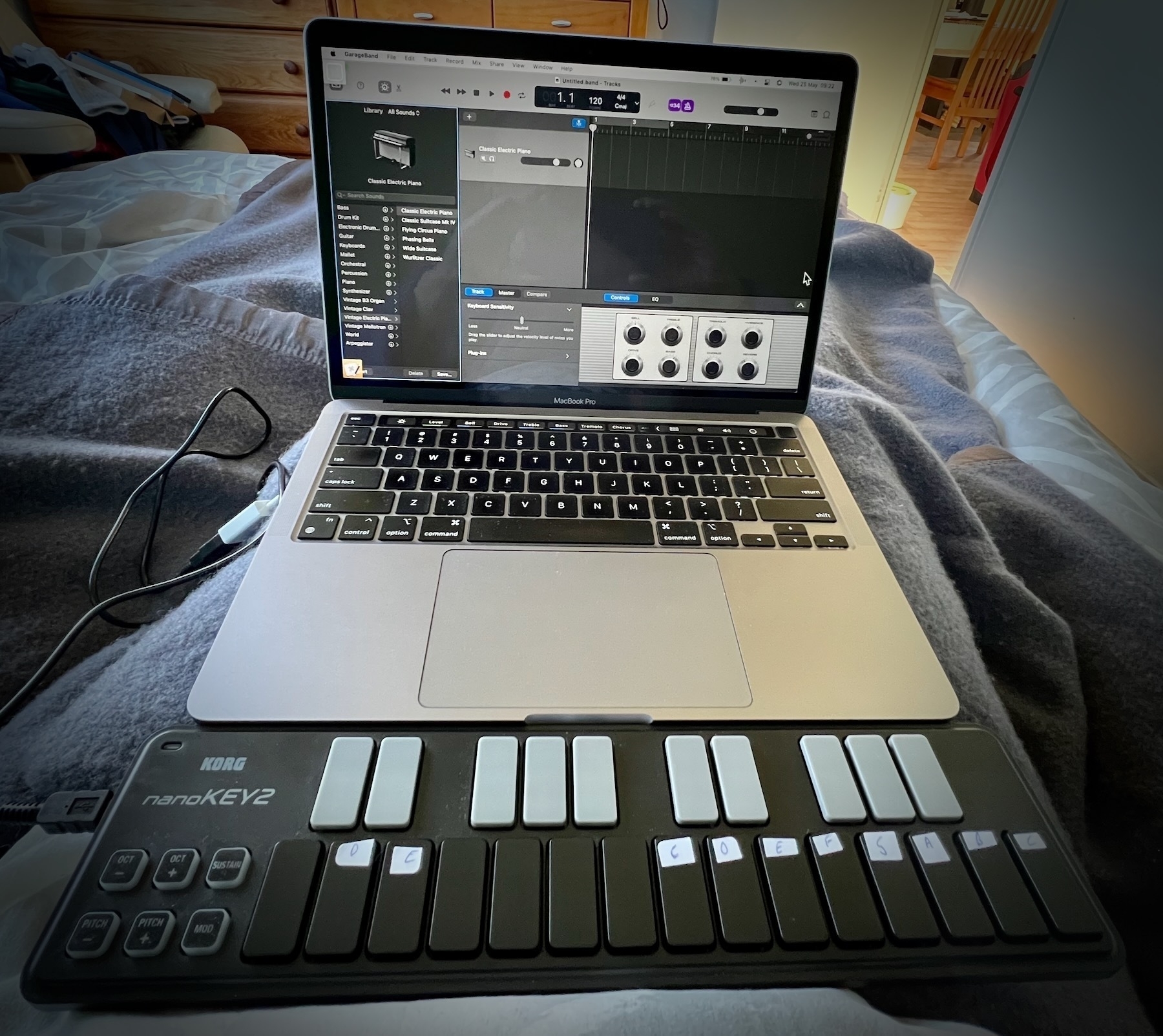 Music keyboard in front of open laptop. 