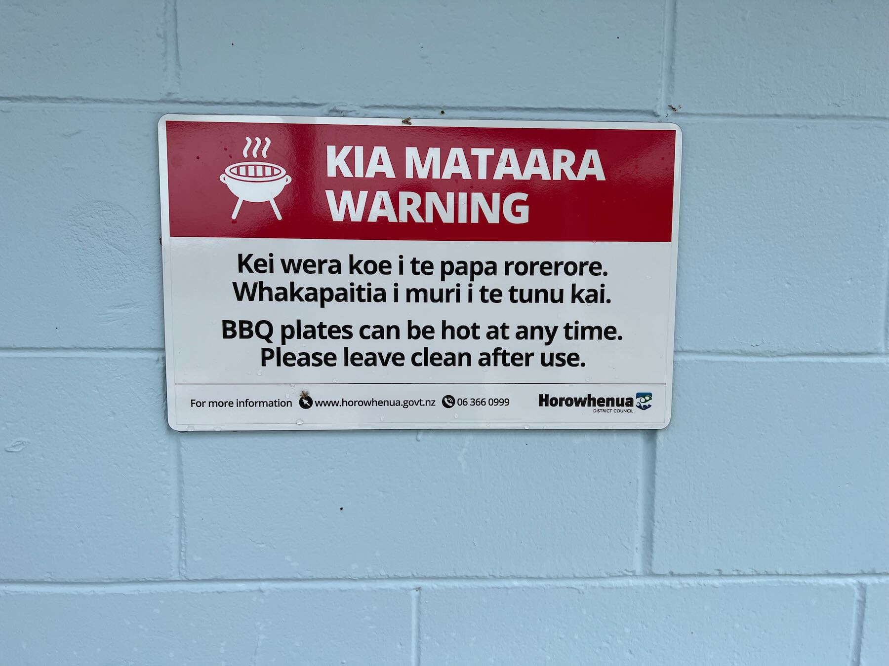 Bilingual warning that the BBQ may be hot. 