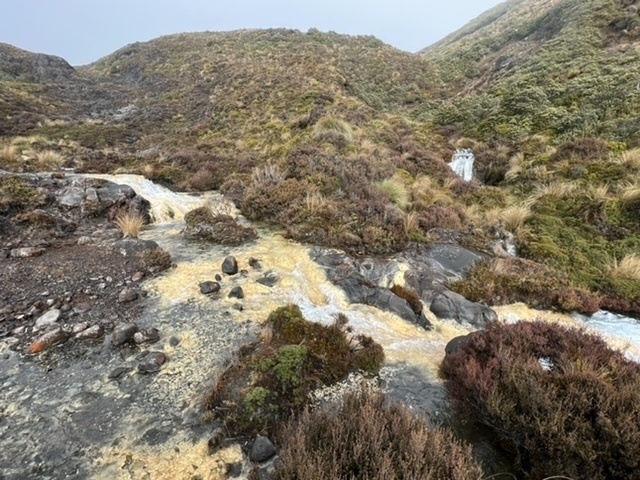 yellow rocks in water in a mountain desert landscape. 