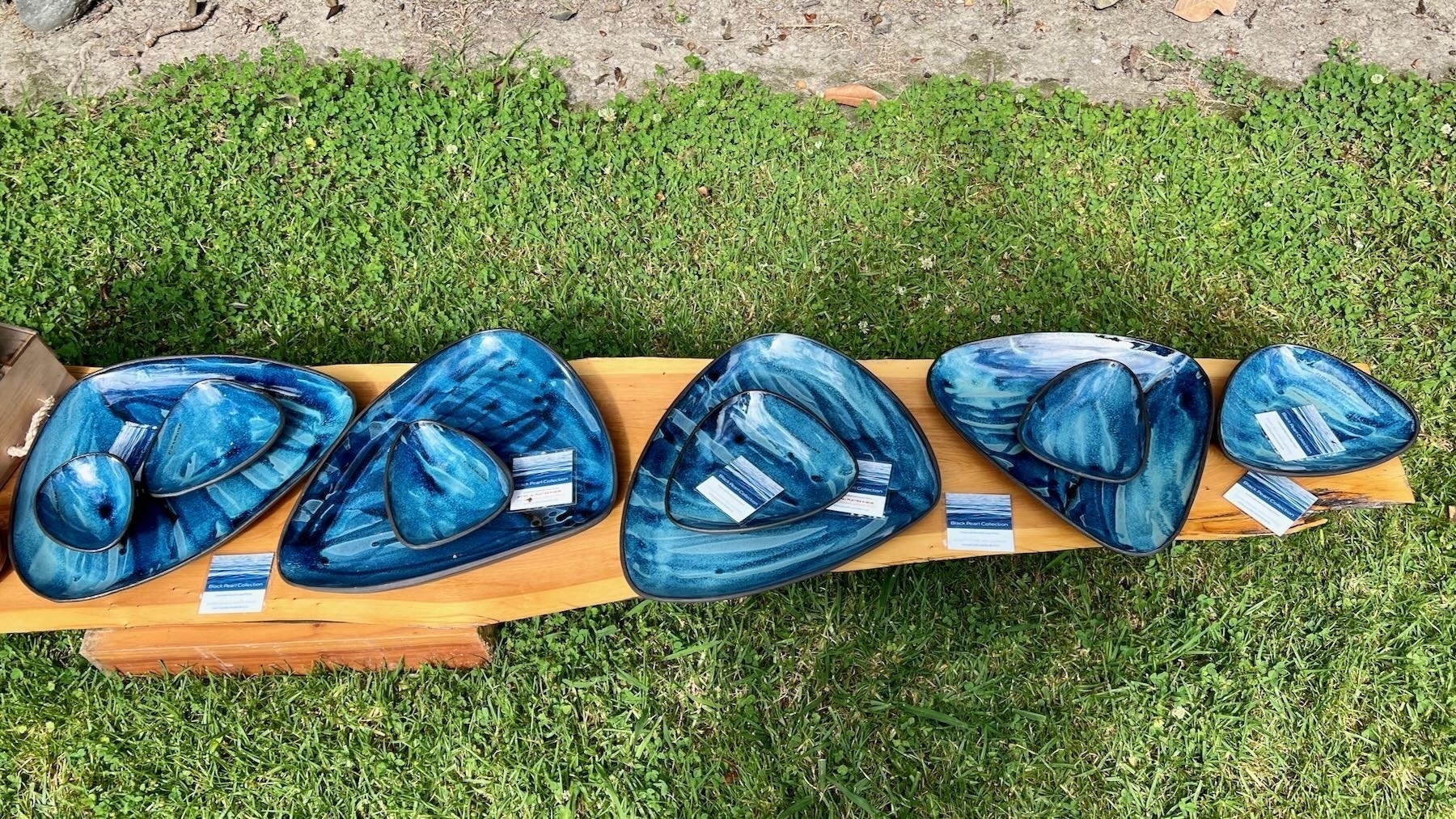 Blue dishes displayed on a wooden bench. 