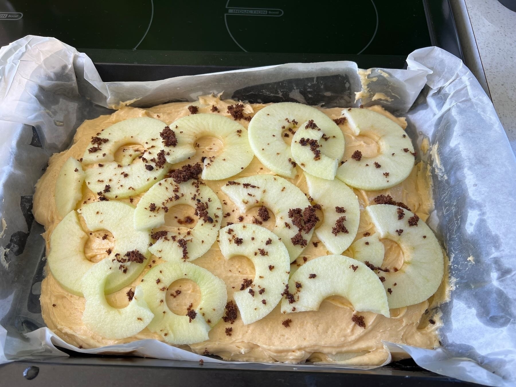 The layered apple and mix in the tray with sugar sprinkled on top. 