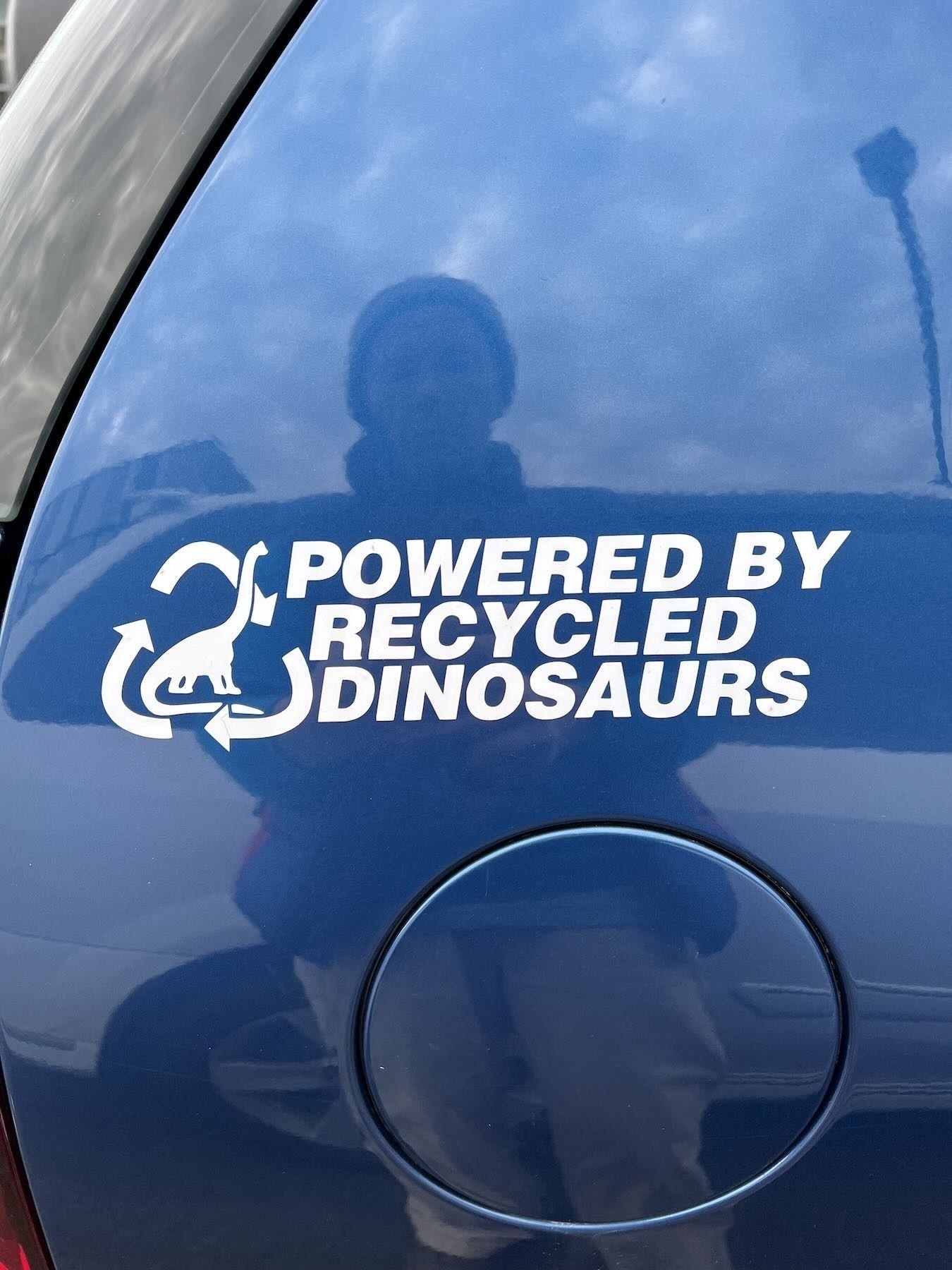 Decal on a petrol car that says: Powered by recycled dinosaurs. 