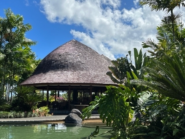 Traditional style Samoan fale, with open sides and a distinctively shaped tiled roof. 