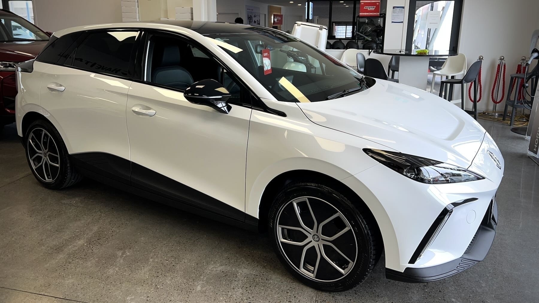 MG 4 Essence 64, white car with black roof and trim. 