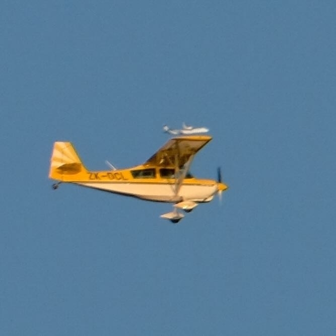 Extreme crop shows a commercial jet seemingly balanced on top of the wingtip of the small plane. 