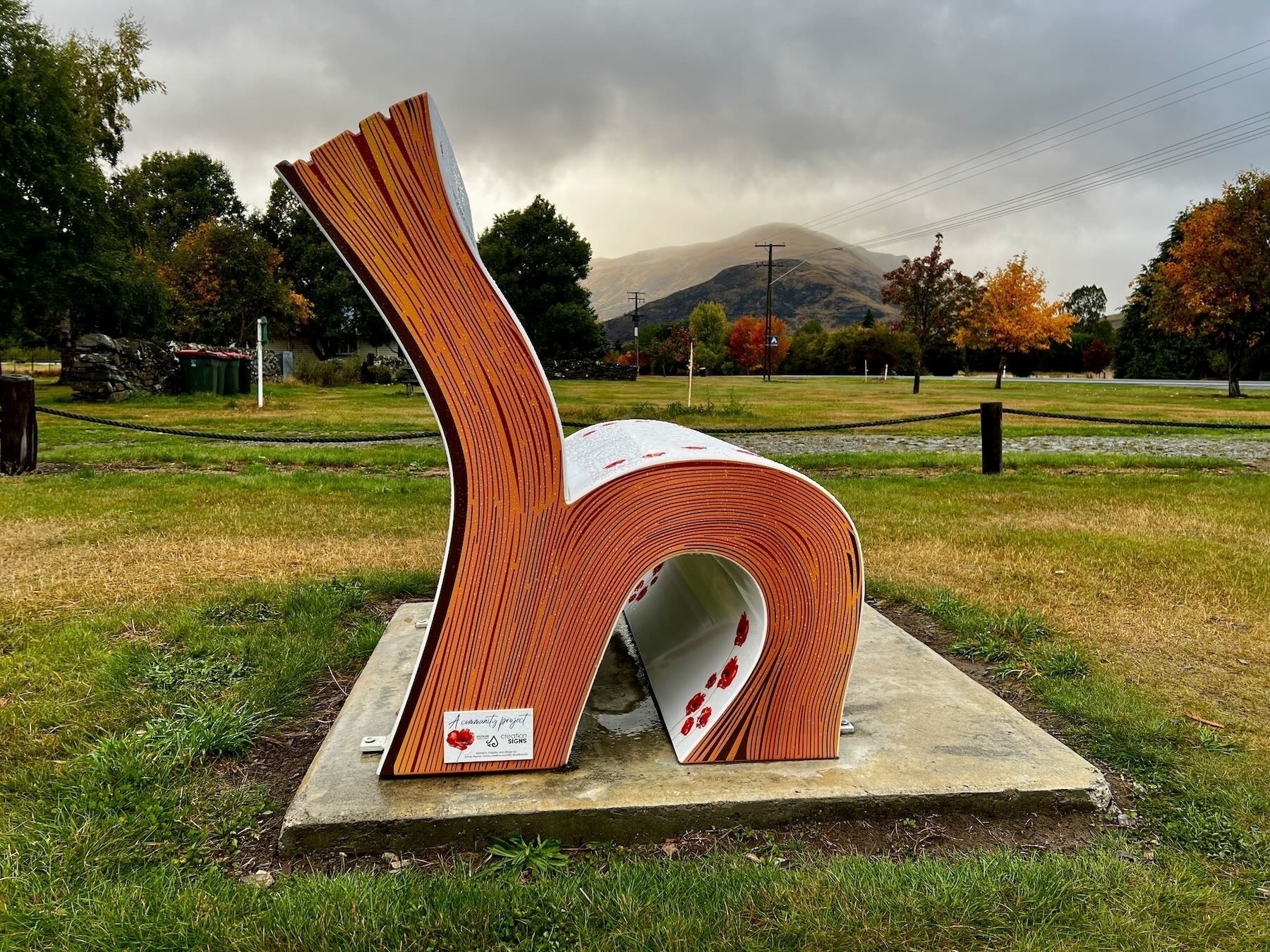 Athol RSA memorial seat shaped like an open book with some pages upright and others rolled over to form a seat.
