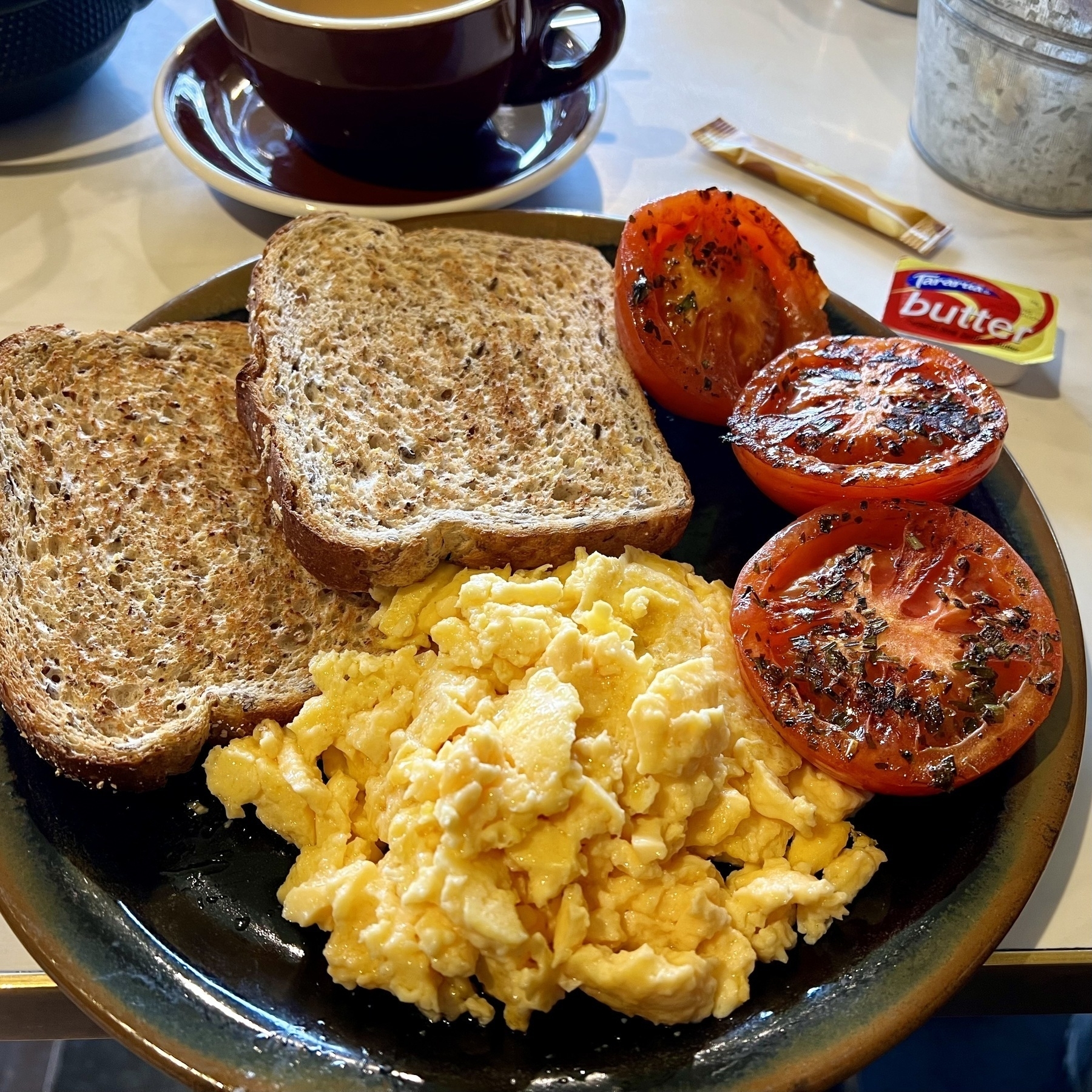 Toast, scrambled eggs, tomatoes. 