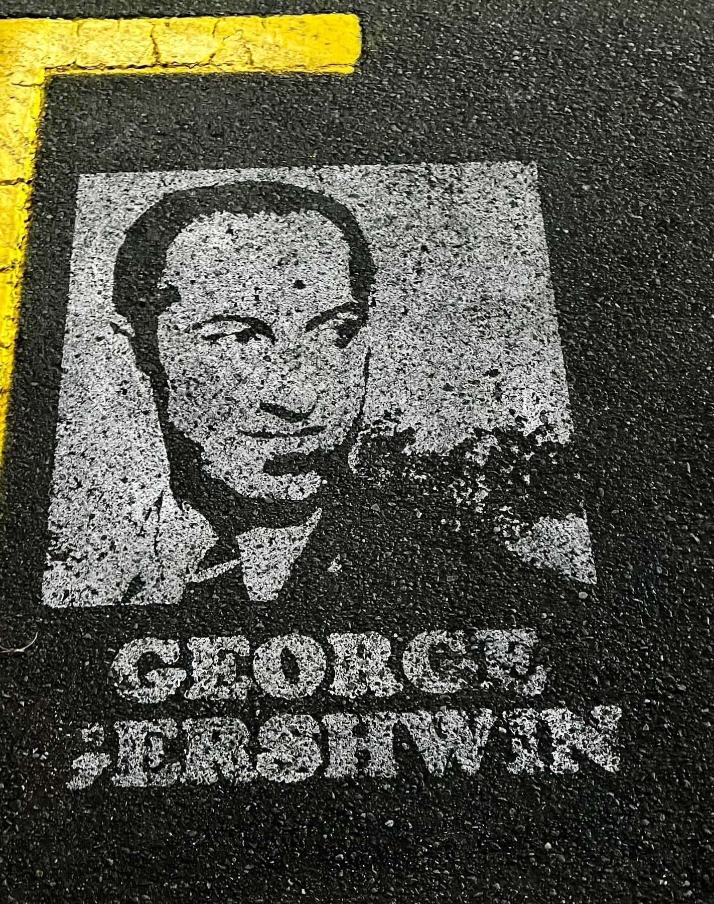 Stencil of George Gershwin on a street.