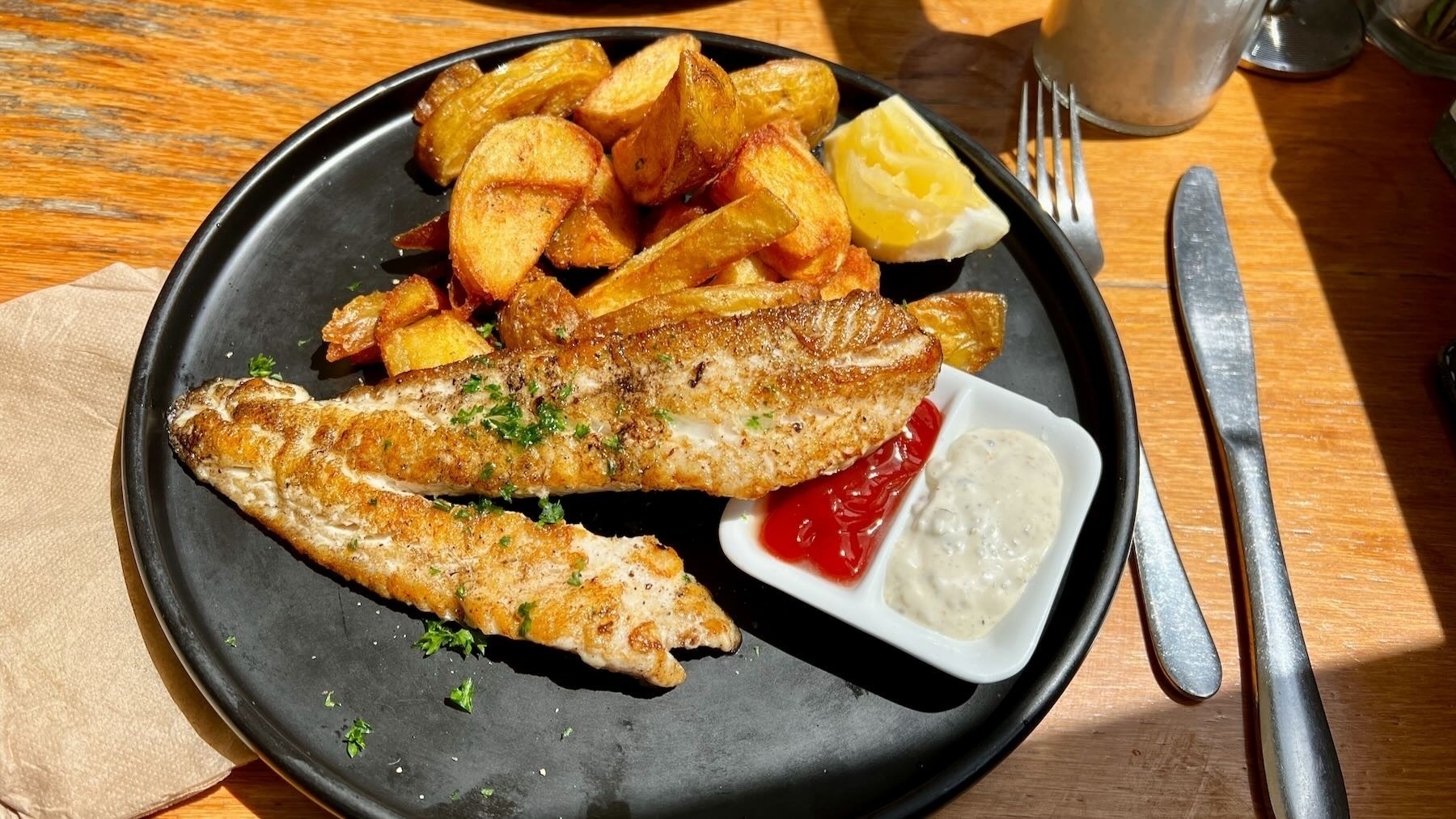 Plate of fish and chips, with tomato and Bearnaise sauces.