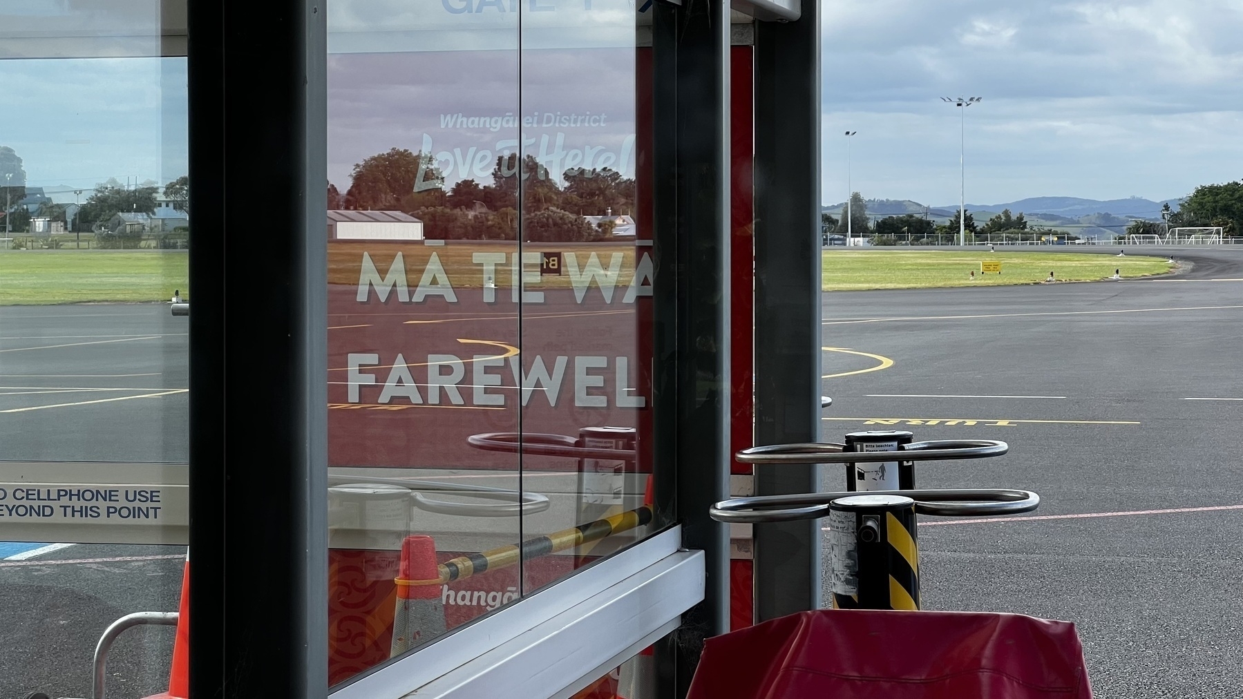 Airport with farewell sign in Māori and English. 