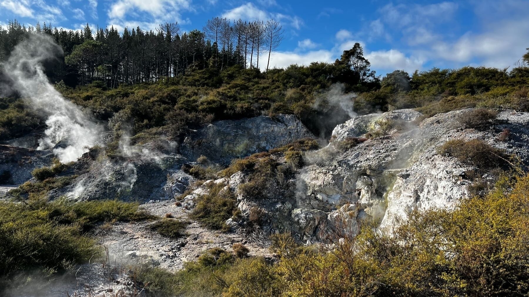 Scrub, white rocks and craters, steam.