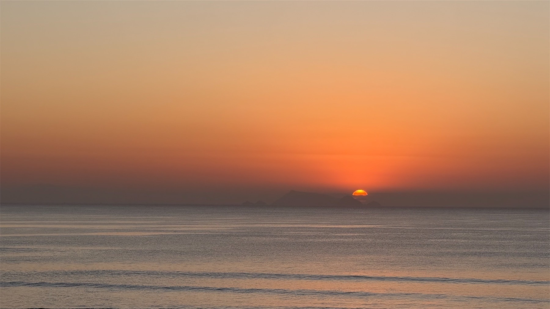 A sliver of sun is visible with a bright spot at the top. 