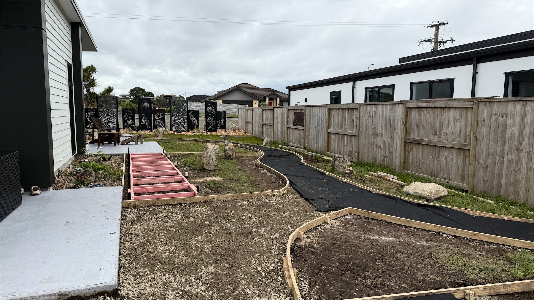 Wooden boards and weedmat define paths and planted areas.