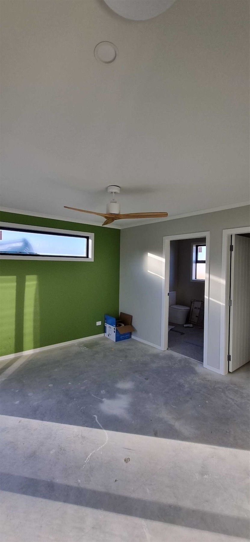 Fan in a bedroom that has an ensuite and a feature wall.