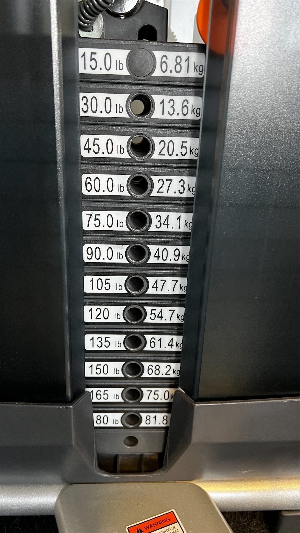 Weight plates marked in round multiples of pounds and also in weird kilo conversions. 