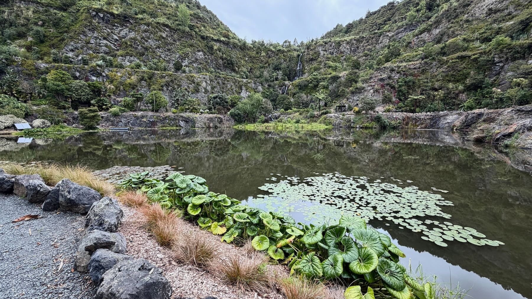 Lake fed by big waterfall with steep rocky sides.