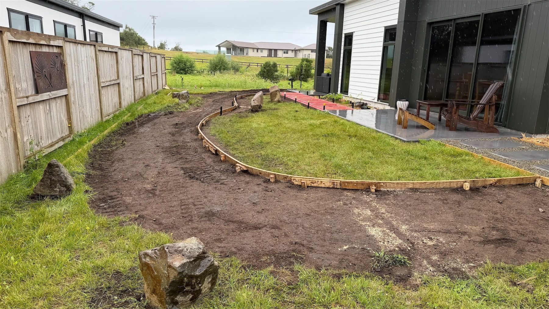 A small grassy area, much of which has been torn up, creating a curved path of bare soil. 