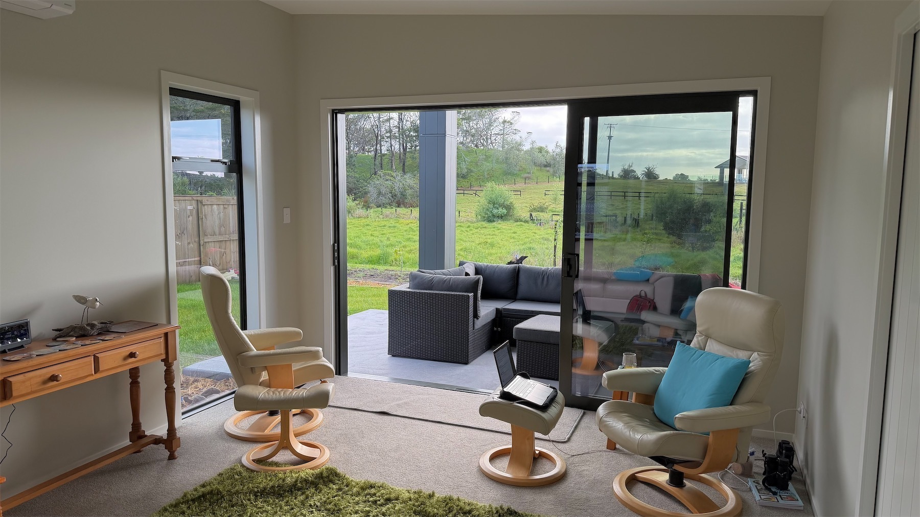 Square room with a couple of easy chairs and a large sliding door.