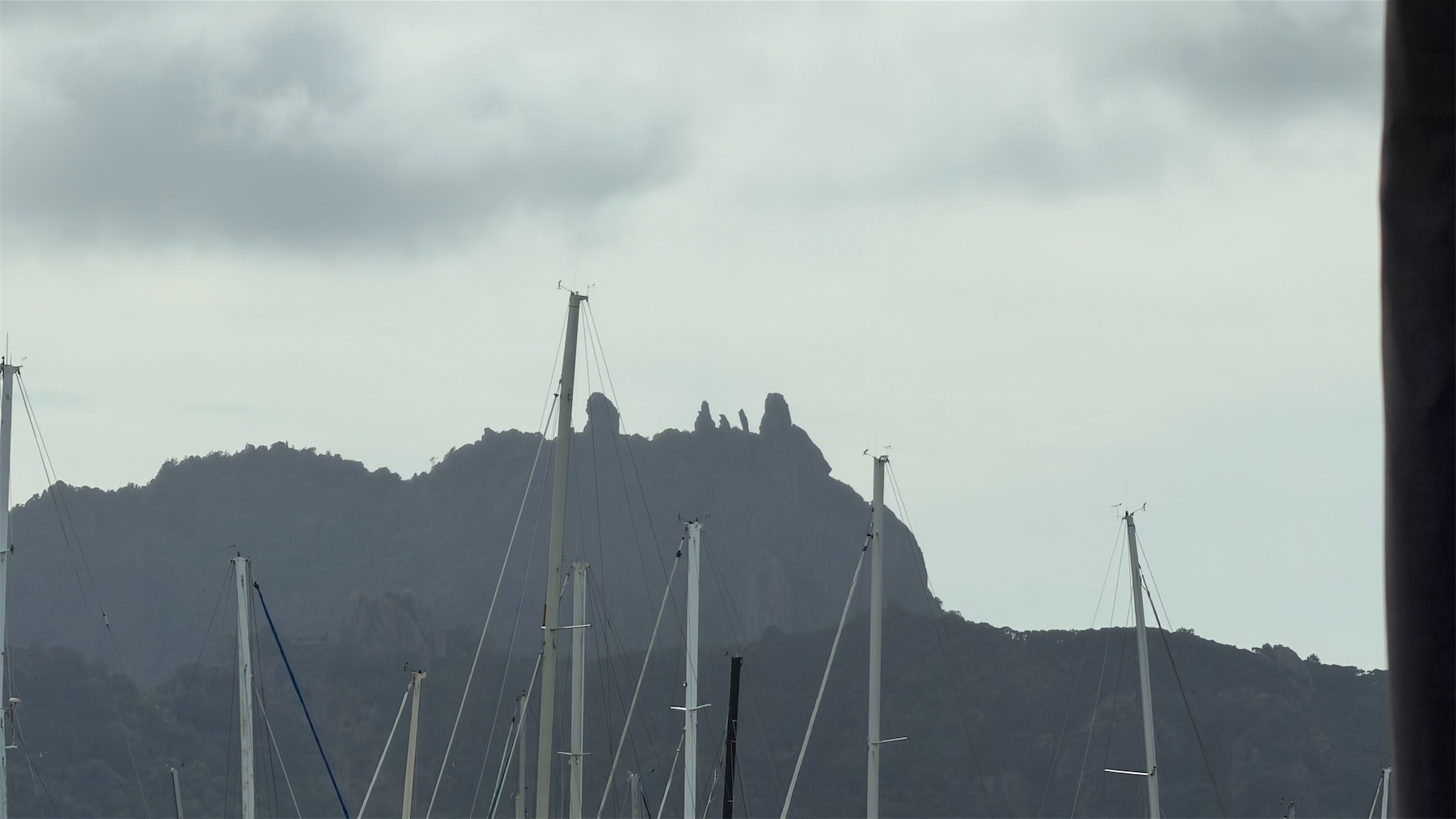 Behind yacht masts in the foreground are the craggy rocks on Mt Manaia.