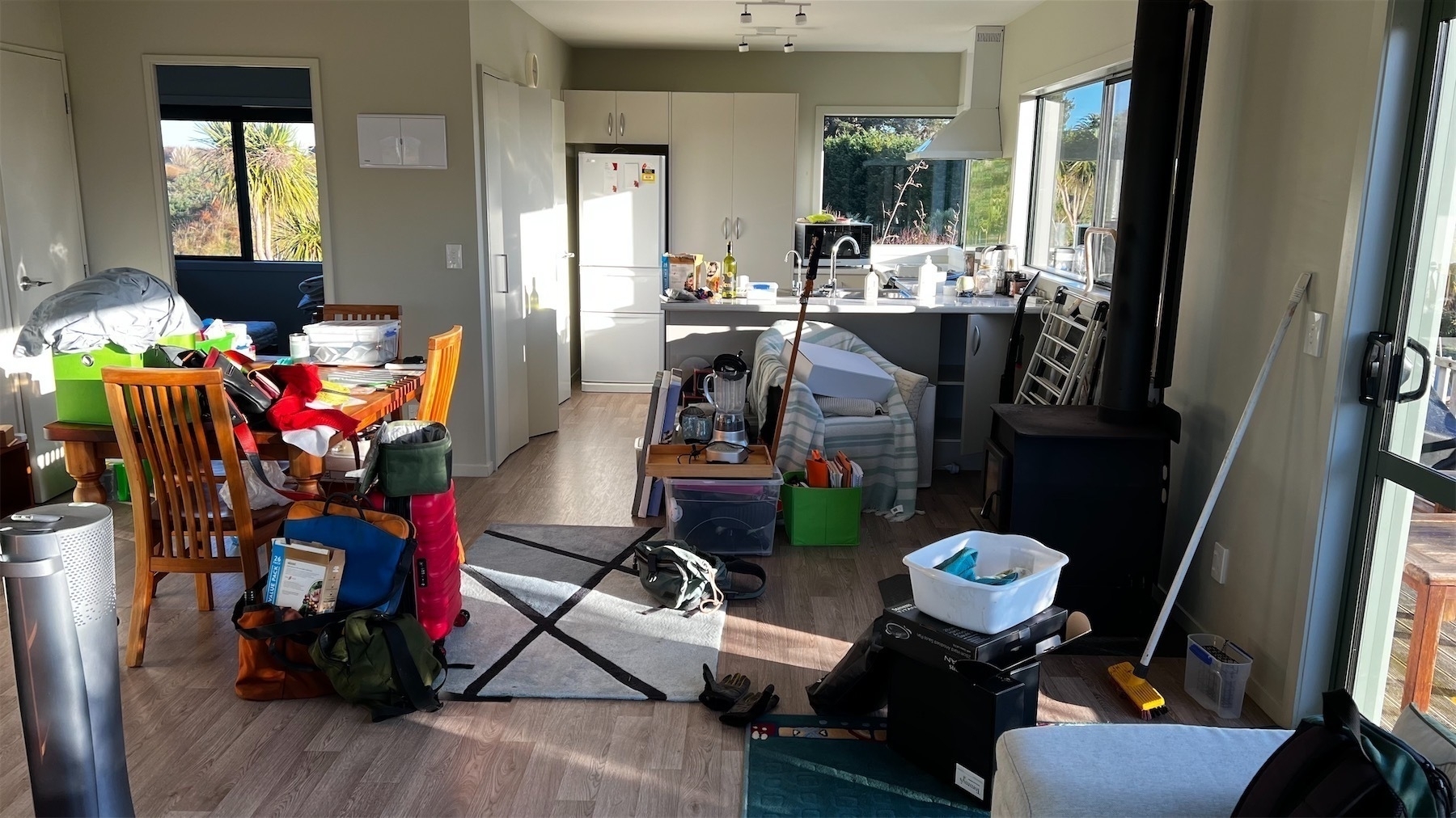 Prepack chaos - household goods are scattered all over the lounge and kitchen of a small house.